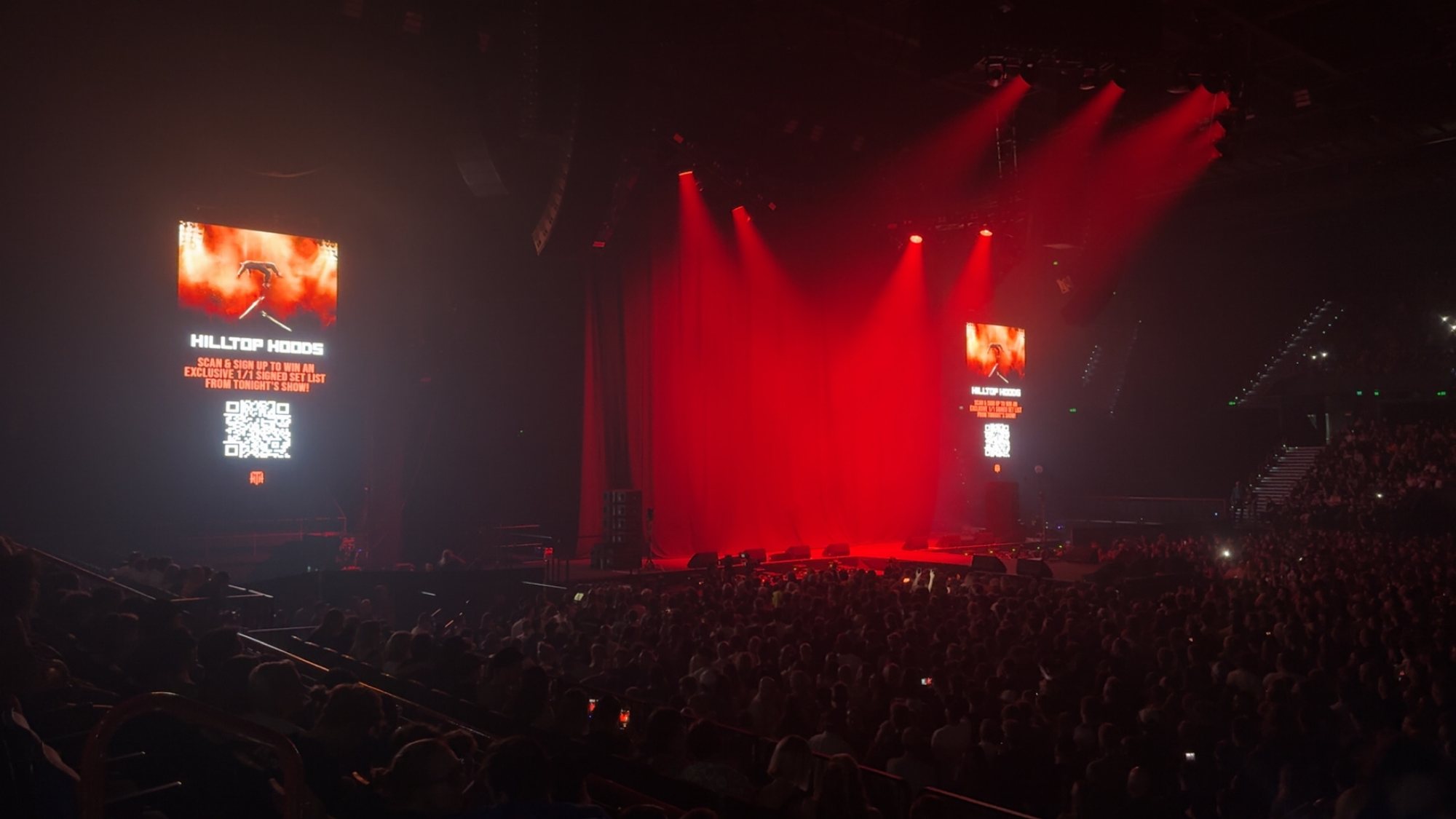 The Brisbane Entertainment Centre stage under red lighting before Hilltop Hoods performed