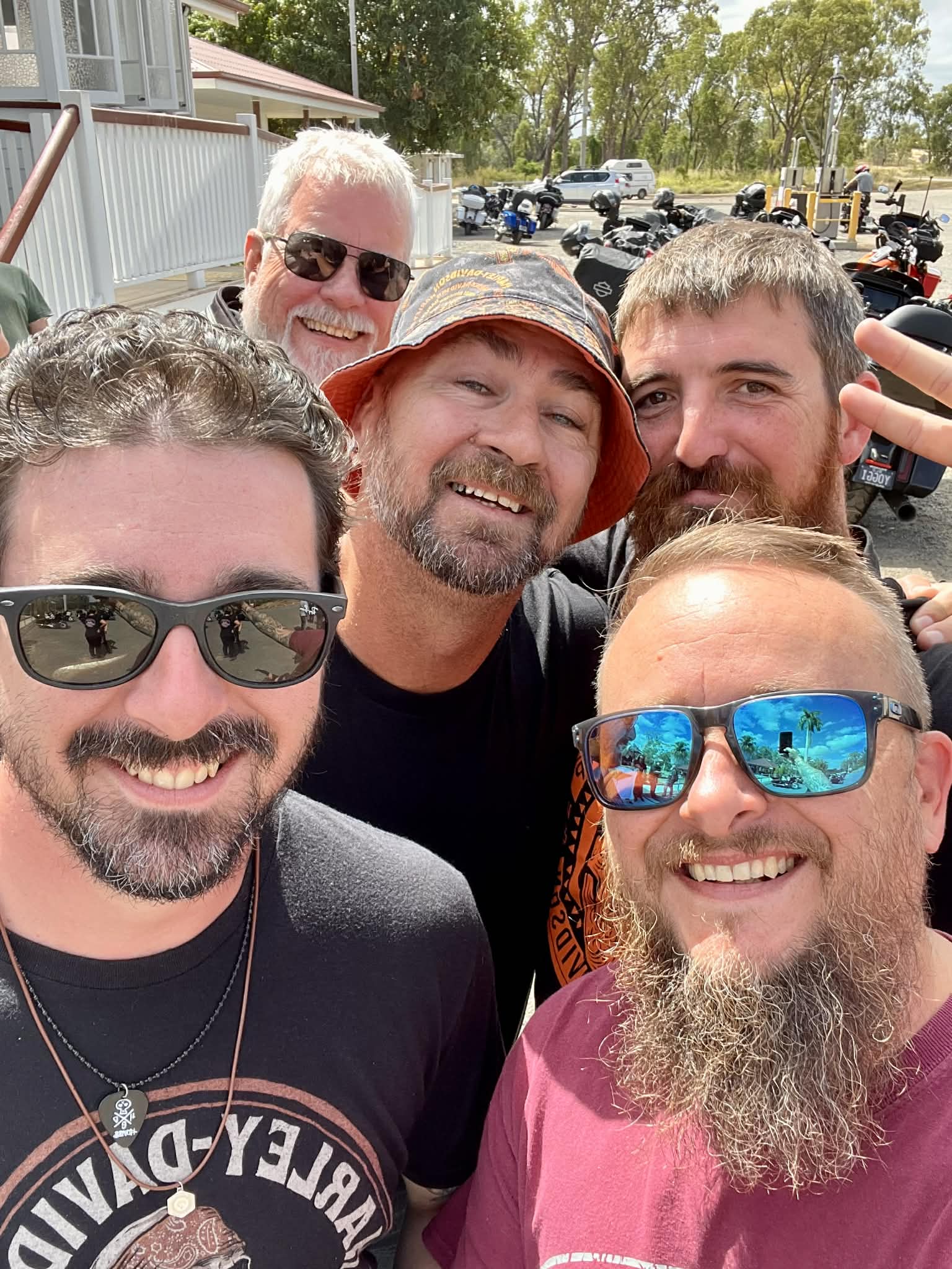 Five riders smiling for a group selfie.