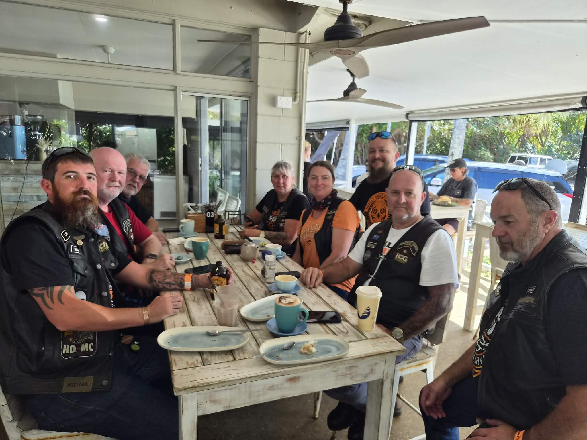 Rally riders seated around a table during a café stop.